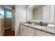 Bathroom featuring double sinks, white cabinets, and granite counters at 3615 S Church Ave, Tampa, FL 33629