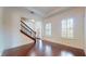 Bright living room featuring hardwood floors, white walls, a staircase, and plantation shutters at 3615 S Church Ave, Tampa, FL 33629