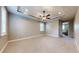 Spacious main bedroom featuring neutral carpeting, a tray ceiling with fan, and bright windows at 3615 S Church Ave, Tampa, FL 33629
