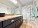 Neutral colored bathroom with vanity, large mirror, bathtub with shower and sea themed decorations at 408 Delwood Breck St, Ruskin, FL 33570