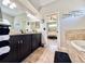 View of a bathroom with a soaking tub, double vanity, and glass-enclosed shower with an ensuite bedroom at 408 Delwood Breck St, Ruskin, FL 33570
