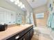 Neutral colored bathroom with vanity, large mirror, bathtub with shower and sea themed decorations at 408 Delwood Breck St, Ruskin, FL 33570