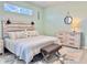 Relaxing bedroom features light walls, wood-look floors, dresser, and bench seating at the end of the bed at 408 Delwood Breck St, Ruskin, FL 33570
