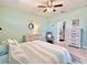 Comfortable bedroom with a ceiling fan, a dresser, an armchair, and ensuite access to a clean bathroom at 408 Delwood Breck St, Ruskin, FL 33570
