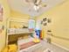 Cheerful bedroom featuring yellow walls, bunk bed, and fan at 408 Delwood Breck St, Ruskin, FL 33570