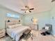 Bright bedroom features a ceiling fan, lots of natural light, a dresser and an armchair with footstool at 408 Delwood Breck St, Ruskin, FL 33570