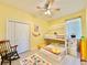 Cheerful bedroom with yellow walls, ceiling fan, bunk bed, rug, and closet at 408 Delwood Breck St, Ruskin, FL 33570