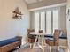 Cozy dining area with a white table and wicker chairs, complemented by a window bench and neutral tones at 408 Delwood Breck St, Ruskin, FL 33570