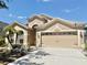 Tan home with a two-car garage and well-kept landscaping and concrete driveway at 408 Delwood Breck St, Ruskin, FL 33570