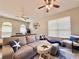 Comfortable living room featuring a sectional sofa, ceiling fans, and a large window at 408 Delwood Breck St, Ruskin, FL 33570