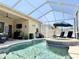 Beautiful screened-in pool with a spa, sun umbrella, and outdoor seating at 408 Delwood Breck St, Ruskin, FL 33570