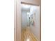 Hallway with wood-look flooring leading to various rooms, showcasing a neutral color scheme and artwork at 4221 W Spruce St # 2422, Tampa, FL 33607