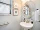 Cozy half bathroom with a pedestal sink, framed art, and natural lighting at 4689 Wandering Way, Wesley Chapel, FL 33544