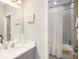 Clean bathroom with a single sink vanity, a framed mirror, and a shower/tub combo with white shower curtain at 4689 Wandering Way, Wesley Chapel, FL 33544