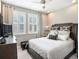 Cozy bedroom with a queen-sized bed, neutral color palette, and natural light from windows with shutters at 4689 Wandering Way, Wesley Chapel, FL 33544