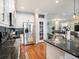 Open kitchen featuring stainless steel appliances, granite countertops, wood floors, and breakfast bar at 4689 Wandering Way, Wesley Chapel, FL 33544