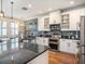 Modern kitchen featuring granite countertops, stainless steel appliances, white cabinetry, and decorative backsplash at 4689 Wandering Way, Wesley Chapel, FL 33544