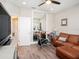 Cozy living room with a large mirror, comfortable brown leather sofa, and wood-look flooring at 4689 Wandering Way, Wesley Chapel, FL 33544