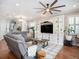 Inviting living room featuring hardwood floors, a large entertainment center, and a ceiling fan at 4689 Wandering Way, Wesley Chapel, FL 33544