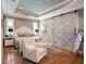 Relaxing main bedroom featuring a tray ceiling, white furniture, and a sliding barn door at 4689 Wandering Way, Wesley Chapel, FL 33544
