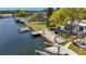 Aerial view of the backyard featuring a dock, lift, lush landscaping, water views and outdoor seating at 4920 Pelican Dr, New Port Richey, FL 34652