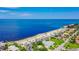 Scenic aerial view of waterfront homes along a sandy beach with crystal clear ocean water at 4920 Pelican Dr, New Port Richey, FL 34652