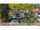 Aerial view of the home's backyard featuring a patio, dining, grill, lush lawn, mature trees and white picket fence at 4920 Pelican Dr, New Port Richey, FL 34652