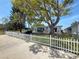 This backyard features mature trees and landscaping with a white picket fence surrounding at 4920 Pelican Dr, New Port Richey, FL 34652