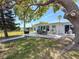 This backyard offers an outdoor dining set, grill, and a large tree providing ample shade at 4920 Pelican Dr, New Port Richey, FL 34652