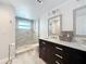 This bathroom features a glass enclosed shower and a double vanity with framed mirrors at 4920 Pelican Dr, New Port Richey, FL 34652