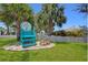 Welcoming beach entrance with a sign, wooden bench, and lush green lawn and palms at 4920 Pelican Dr, New Port Richey, FL 34652