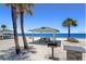 Beach pavilion with picnic tables, grill and palm trees against a clear blue sky at 4920 Pelican Dr, New Port Richey, FL 34652