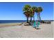 Inviting beach setting with comfortable seating, palm trees, and clear blue skies at 4920 Pelican Dr, New Port Richey, FL 34652