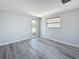 Bright bedroom with hardwood-style floors, neutral walls, and a pair of window views at 4920 Pelican Dr, New Port Richey, FL 34652