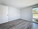 Clean and simple bedroom design with wood-look floors and natural light from the window at 4920 Pelican Dr, New Port Richey, FL 34652