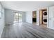 Spacious room with wood-look floors, sliding door, and access to a bathroom and laundry area at 4920 Pelican Dr, New Port Richey, FL 34652