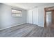 A simple and well-lit bedroom features wood-look floors and a spacious closet at 4920 Pelican Dr, New Port Richey, FL 34652