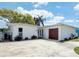 A well-kept single-story home featuring a clean, white facade, a modern front door, and a single-car garage at 4920 Pelican Dr, New Port Richey, FL 34652