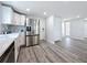 Bright kitchen featuring stainless steel refrigerator, white cabinets, and wood-look flooring at 4920 Pelican Dr, New Port Richey, FL 34652