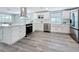 This updated kitchen features stainless steel appliances, white cabinets, and wood-look flooring at 4920 Pelican Dr, New Port Richey, FL 34652