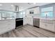 Charming kitchen with white cabinetry, stainless steel dishwasher, and farmhouse sink at 4920 Pelican Dr, New Port Richey, FL 34652
