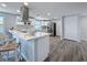 Bright, updated kitchen with stainless steel appliances, an island, and stylish wood-look tile floors at 4920 Pelican Dr, New Port Richey, FL 34652