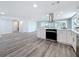 Open concept kitchen with white cabinets, stainless steel appliances, and wood-look flooring at 4920 Pelican Dr, New Port Richey, FL 34652