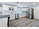 Updated kitchen with white cabinets, stainless steel appliances, and a farmhouse sink at 4920 Pelican Dr, New Port Richey, FL 34652