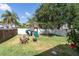 Large backyard with a play-set, fire pit, wood chairs, and green lush manicured lawn at 5607 Tanagergrove Way, Lithia, FL 33547
