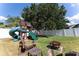 Spacious backyard featuring a wooden playset, fire pit, and well-maintained lawn, perfect for outdoor fun at 5607 Tanagergrove Way, Lithia, FL 33547