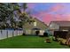 Spacious backyard with lush lawn, patio, fire pit, and cozy seating, perfect for relaxation at 5607 Tanagergrove Way, Lithia, FL 33547
