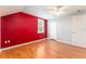 Bedroom with an accent wall, wood-look floors, and vaulted ceilings with a fan and a closet at 5607 Tanagergrove Way, Lithia, FL 33547