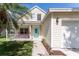 Inviting exterior with light yellow siding, a blue door, and a cozy front porch at 5607 Tanagergrove Way, Lithia, FL 33547