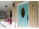 Inviting front porch features a charming blue door and comfortable rocking chairs at 5607 Tanagergrove Way, Lithia, FL 33547